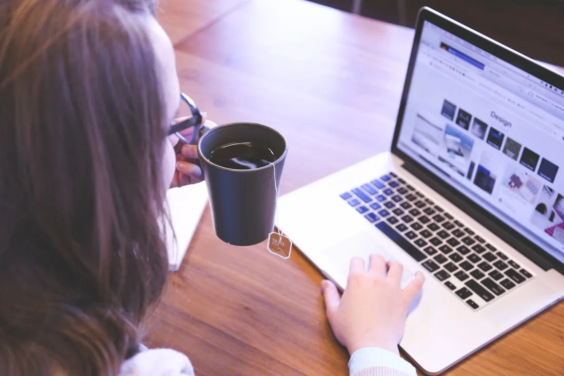 Person working on a laptop with a cup of coffee
